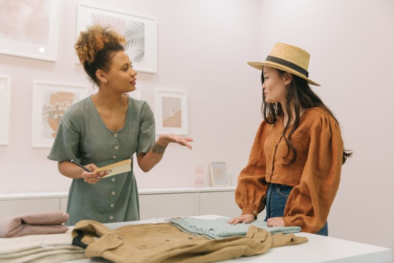 Two women fashion designers discussing and planning together in a stylish indoor setting